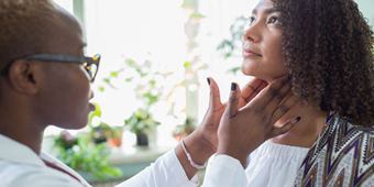 A family doctor performs an examination of a woman's lymph nodes