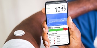A person monitors their diabetes on their mobile device