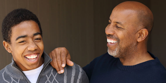 A father and son laugh together while enjoying a special moment.